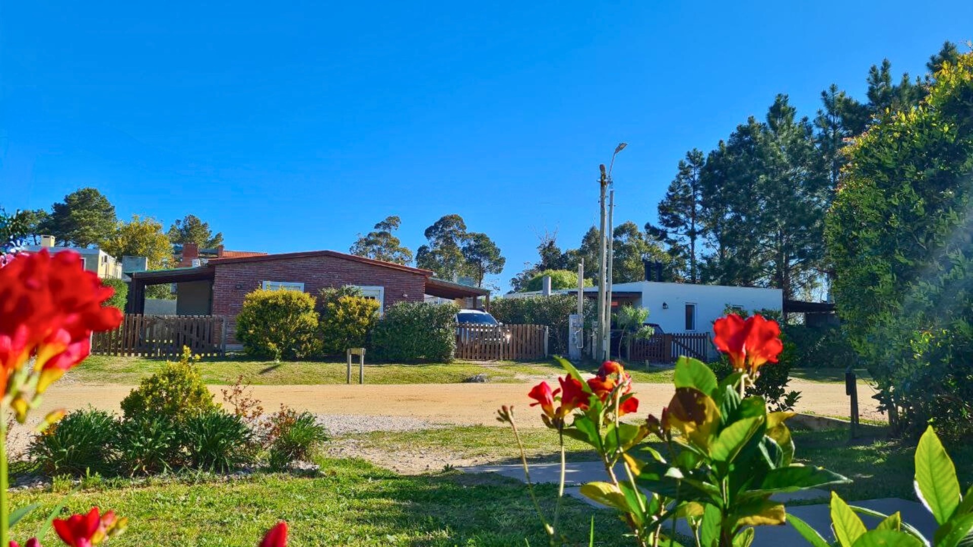 Jardín con flores y cabañas del complejo en un día soleado
