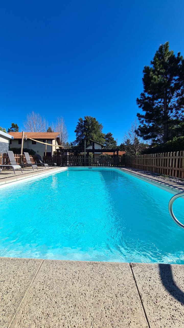 Piscina exterior y jardín del complejo
